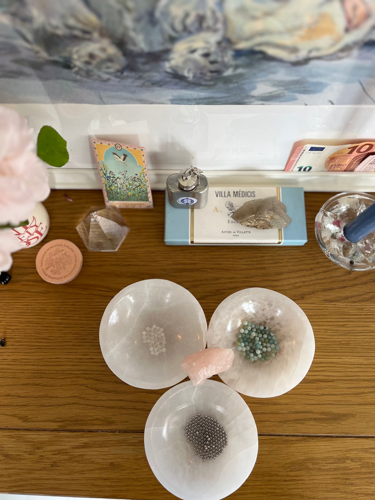 Amazonite and Rainbow Moonstone beads resting in a carved selenite bowl before being handcrafted into a sacred geometric tantric necklace, photographed in natural light.